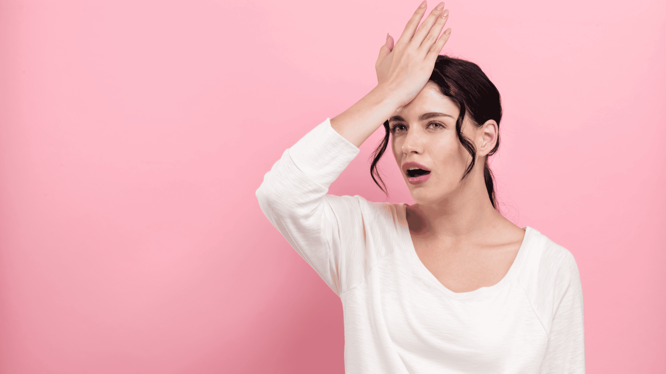 An event planner putting her hand to her head in frustration after realizing a mistake.