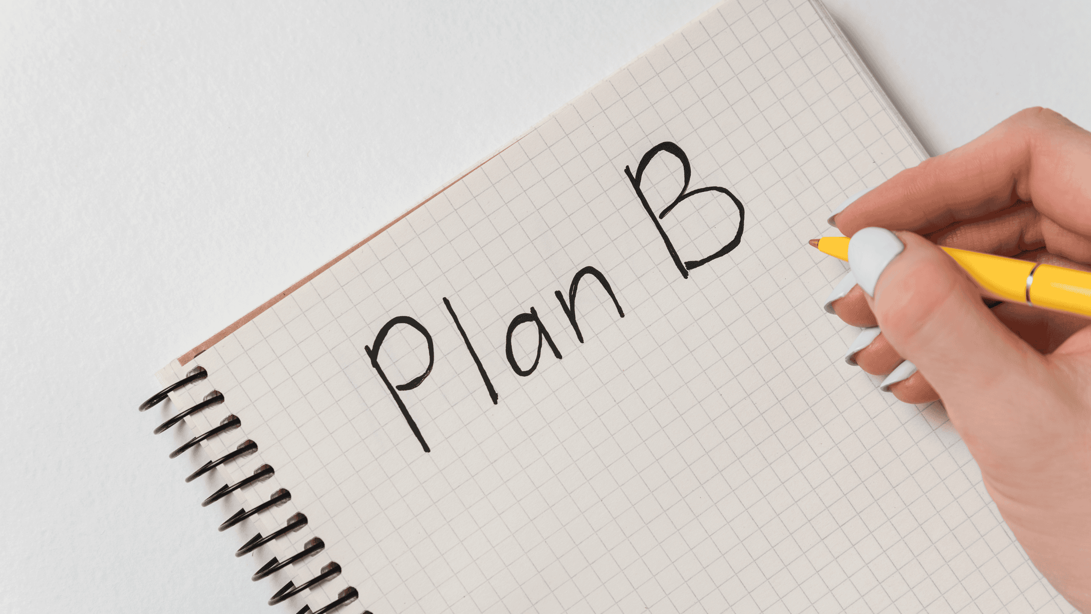Strategic Event Contingency Planning A notebook with a person writing 'Plan B,' symbolizing event contingency planning and backup strategies.