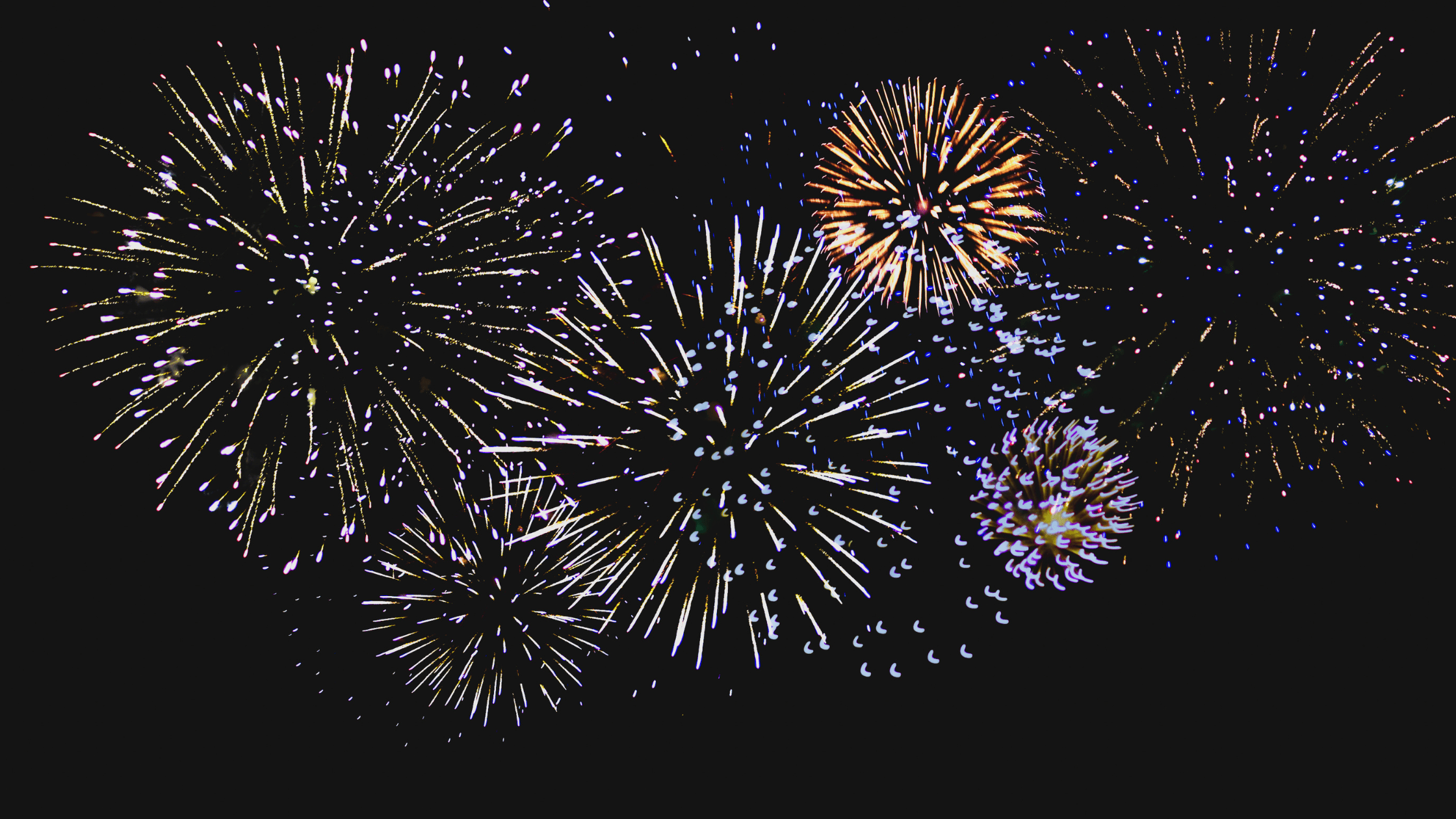 Celebrating the New Year with Fireworks Vibrant New Year fireworks lighting up the dark night sky in a dazzling display.