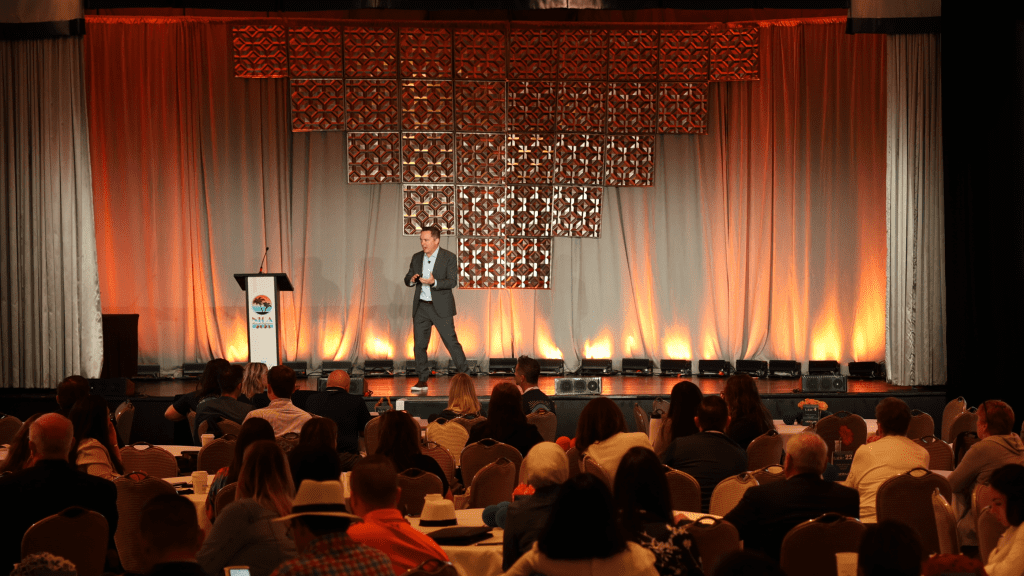 A keynote session at the NICA Annual Conference, with a full room of healthcare professionals facing the stage.