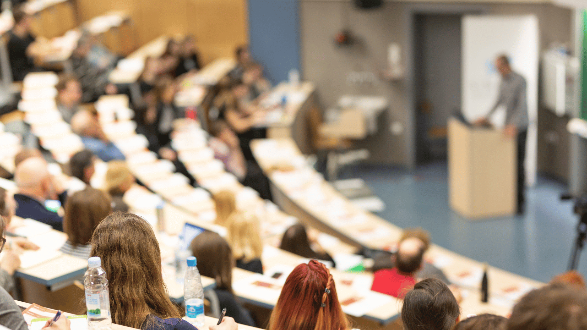 Learning session at a conference with attendees engaged in discussion.