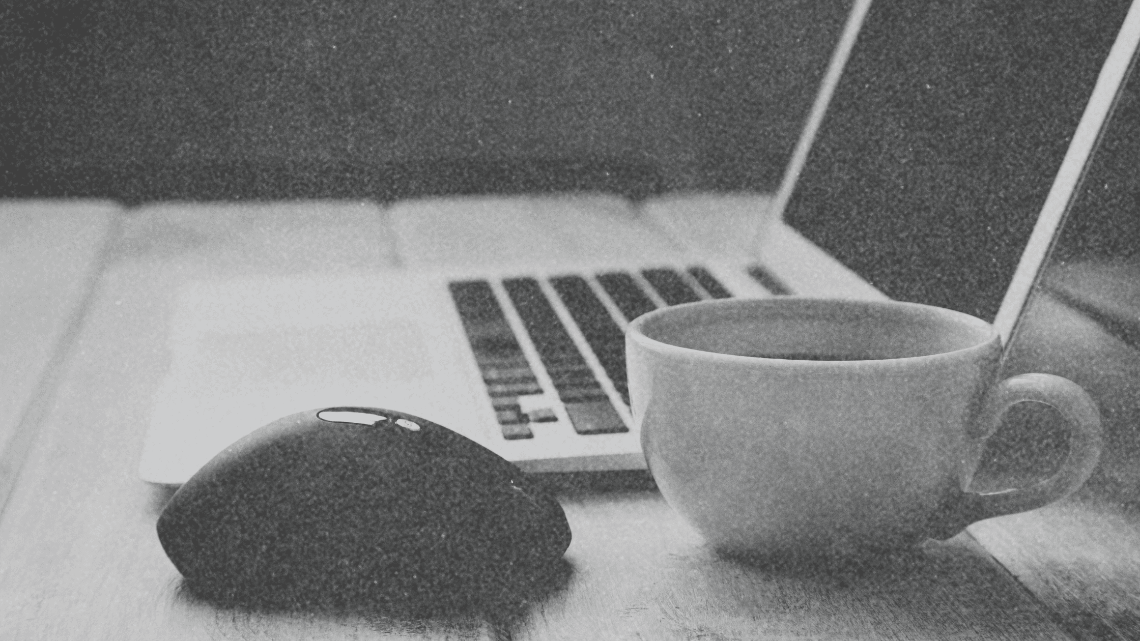 Organized desk with coffee and a computer, set up for a virtual All-Hands Meeting for events and reading blogs.
