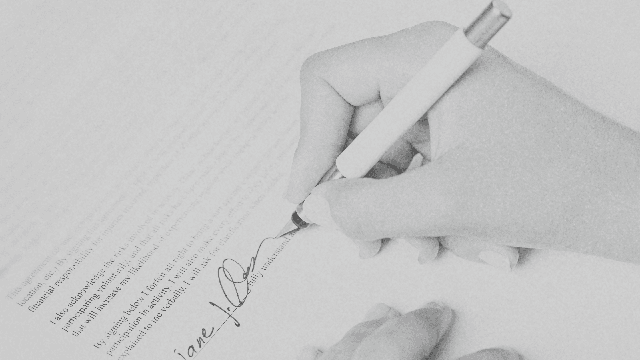 A close-up of a person's hand signing an event planning contract with a pen, symbolizing the importance of strategic event contract negotiation to secure favorable terms and protect budgets.