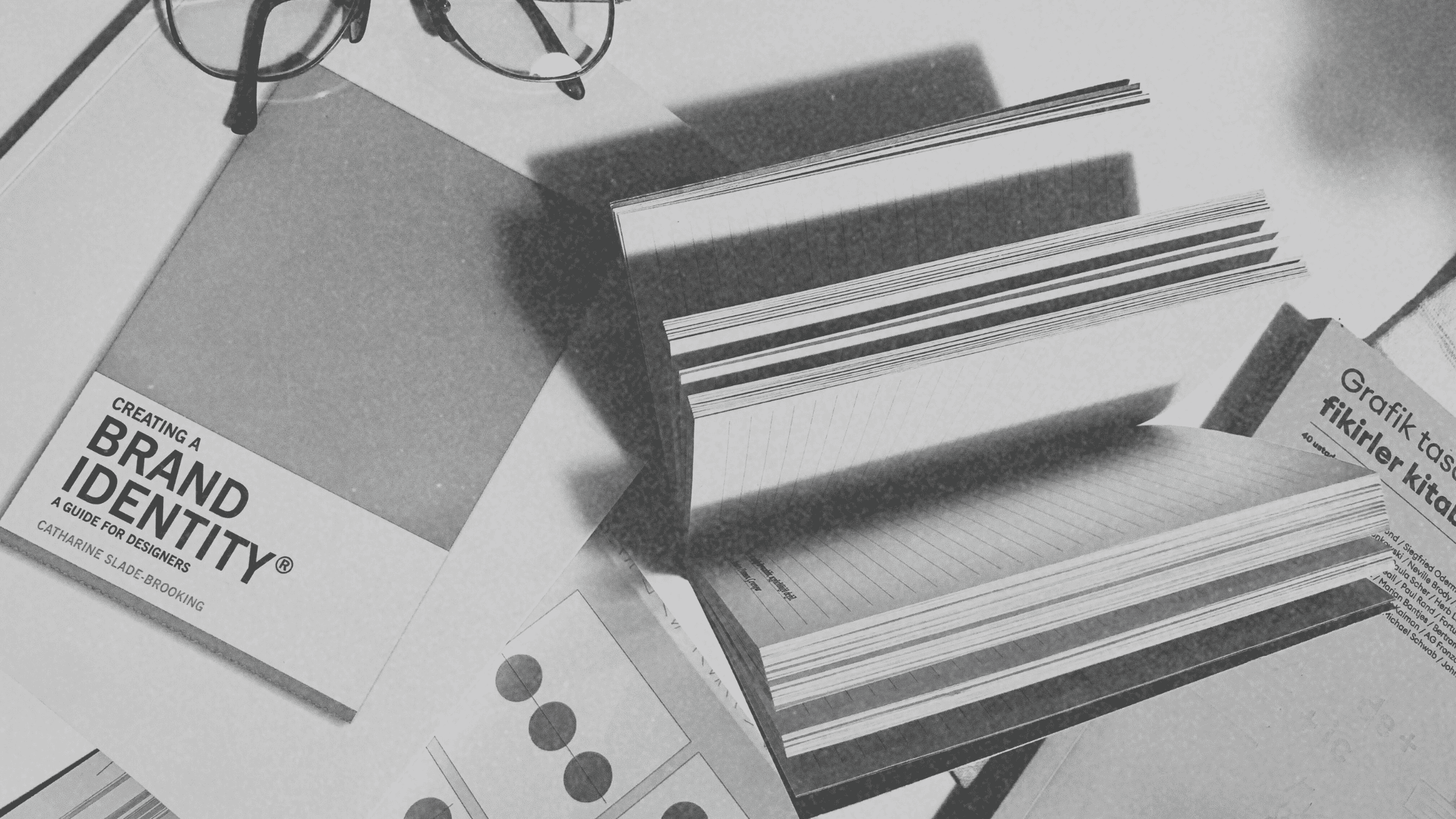 Books and branding guides spread out on a work table, illustrating key concepts of event branding psychology and strategic events.